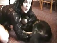 Long haired brunette newcomer to bestiality sex giving a black dog a great blowjob