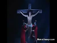 Topless beautiful brunette babe hung naked from a cross for all to see in this BDSM fetish vid